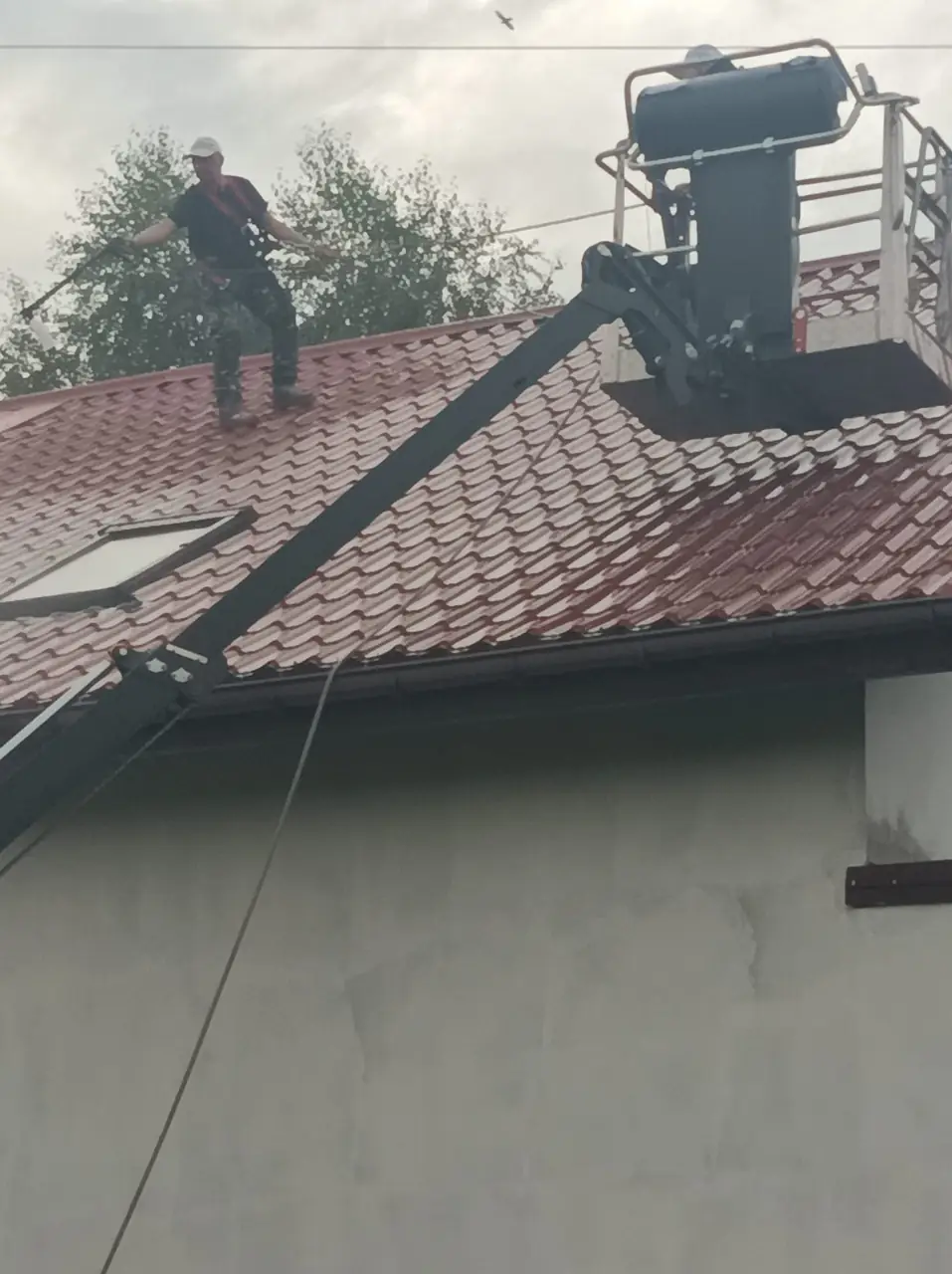 Czyszczenie połaci dachowej z użyciem podnośnika koszowego